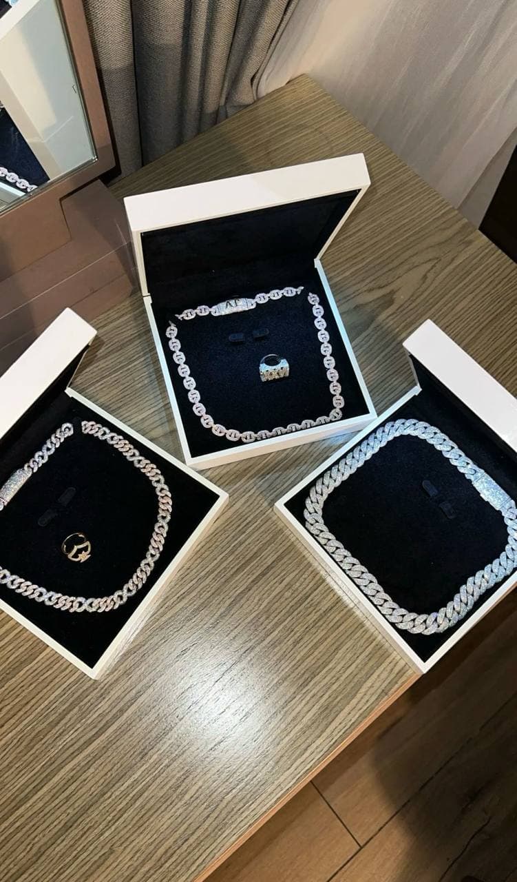 Diamond chains and a ring arranged inside black-lined presentation cases.