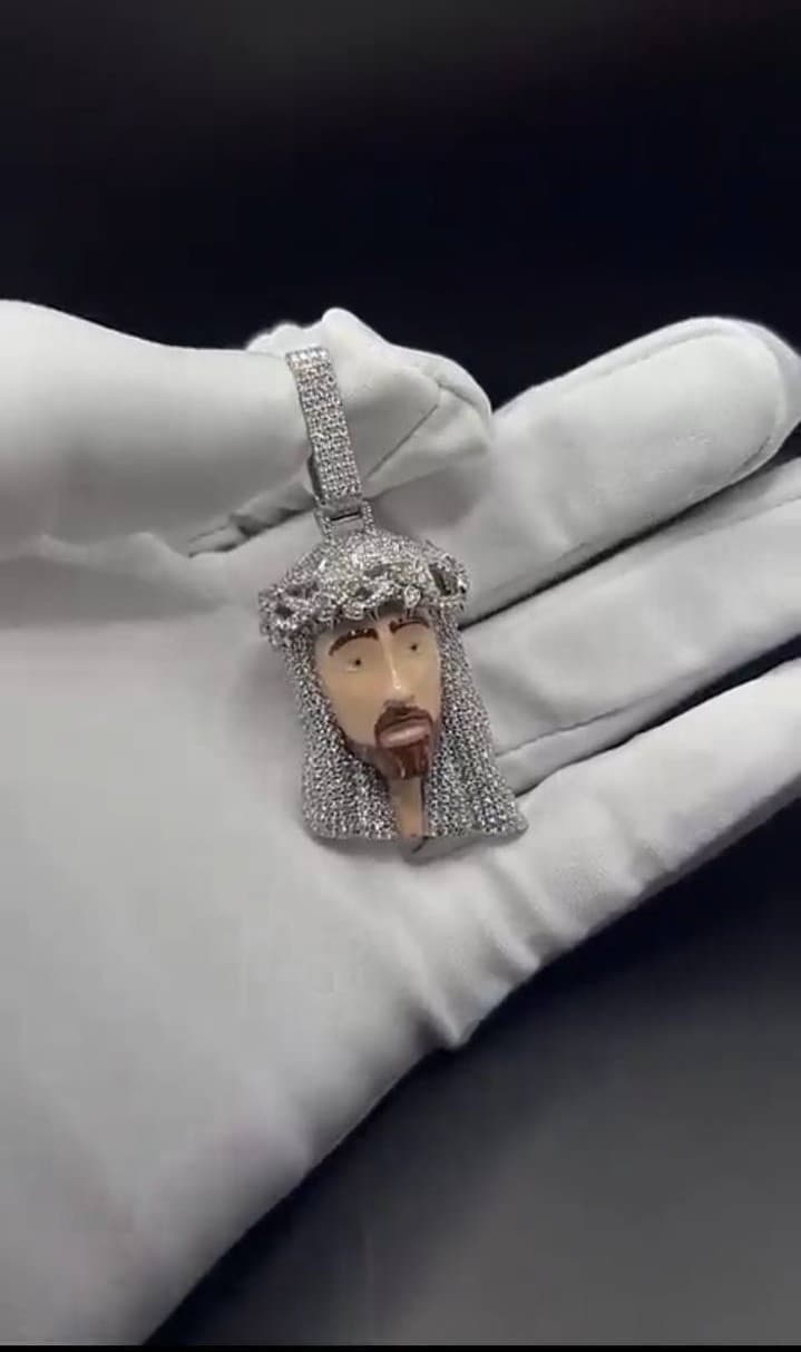 A custom pendant resting on a white glove in a private jewelry presentation.