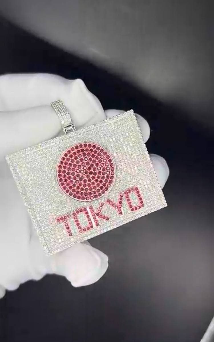 Diamond pendant presented on a white glove for a private XXVI viewing.